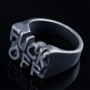 Close-up of punk style matte steel ring with FUCK OFF 3D letter design engraving