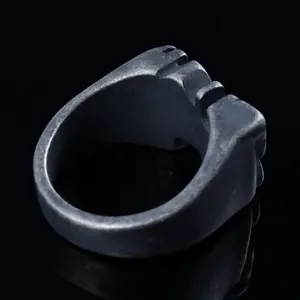 Macro side view of matte grey punk ring with industrial grooved texture on black base