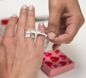 Close-up showing how to measure finger size for the punk letter ring with a soft ruler