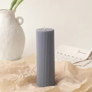 Macro detail of a grey ribbed cylindrical soy candle on rustic brown paper decor