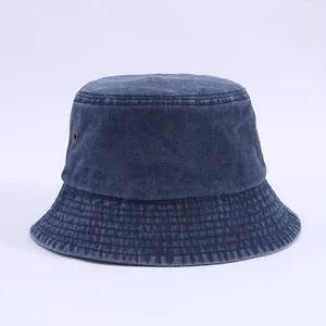 Detail of dark blue denim bucket hat with reinforced stitching and metal eyelets