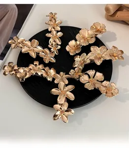 Detailed close-up of golden metal floral hair clips with intricate petal textures