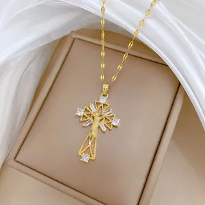 Detail showing the intricate gold cross pendant with micro-paved white zircons on a thin chain