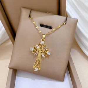 Detailed close-up of a gold cross pendant with cubic zirconia on a luxury jewelry box