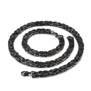Macro detail view showing the textured weave of a black Byzantine chain necklace and bracelet set