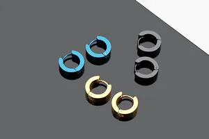 Detailed view of polished titanium steel hoop earrings in blue, gold, and black finishes.