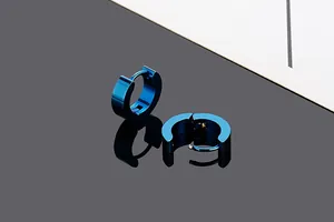 Detailed macro shot of blue titanium steel hoop earrings with reflective finish