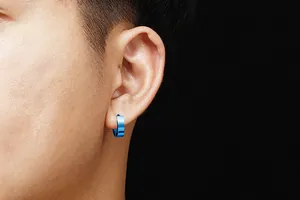 Macro shot showcasing a blue titanium steel hoop earring worn on a person's ear