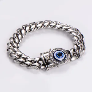 Dettaglio di bracciale cubano in acciaio con occhio di Allah blu e pavé di cristalli.
