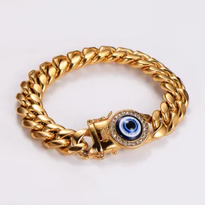 Dettaglio di un bracciale a catena cubana d'oro con un occhio del male blu centrale
