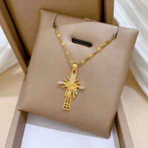 Detail of a gold-plated titanium steel cross necklace featuring pavé zircon in a jewelry box