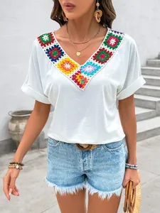 Détail de l'encolure en patchwork au crochet coloré sur un chemisier blanc à col V