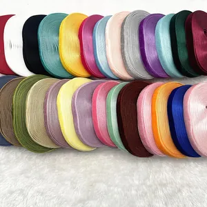Close-up of colorful 1cm velvet ribbons in various shades on a white plush background