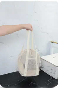 Detail of mesh beach bag with sturdy woven handles and convenient drawstring closure