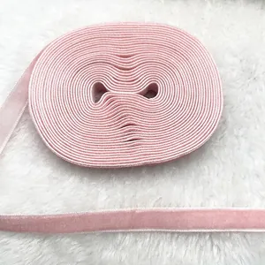Detail of pink velvet ribbon and elastic band for DIY crafts on soft white background