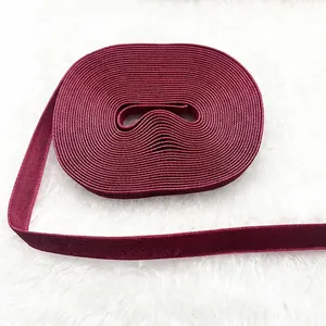 Close-up of 1cm burgundy velvet ribbon roll on white plush background for gift wrapping