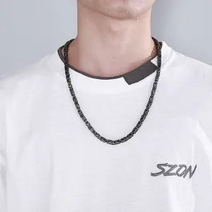 Detail of dark Byzantine chain necklace with intricate woven metal texture on a model