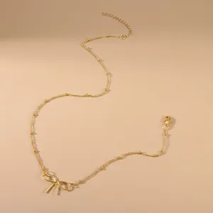 Minimalist gold bow pendant necklace with delicate chain and adjustable lobster clasp