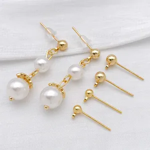 Set di orecchini placcati oro con perle bianche e perni a sfera su tessuto a trama