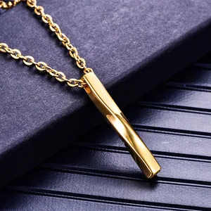 Gros plan d'un pendentif rectangulaire torsadé en acier doré sur un coffret à bijoux bleu