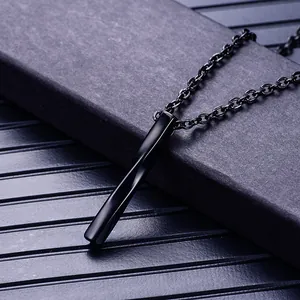 Vue macro d'un pendentif cylindrique noir en acier inoxydable avec finition brillante