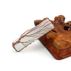 Détail du collier arbre de vie en sélénite enveloppé de fil de cuivre sur bois