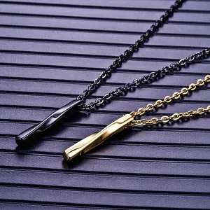 Collier pour homme avec pendentif cylindre torsadé en noir et or sur surface texturée