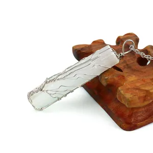 Détail macro du pendentif arbre de vie en cristal de sélénite fait main sur bois