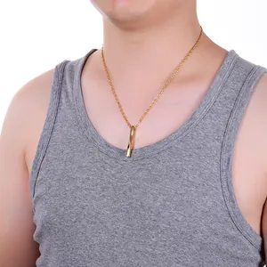 Collier pour homme avec pendentif pilier rectangulaire torsadé doré porté par un mannequin