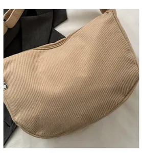 Detail shot of beige corduroy shoulder bag with silver cloud-shaped zipper puller