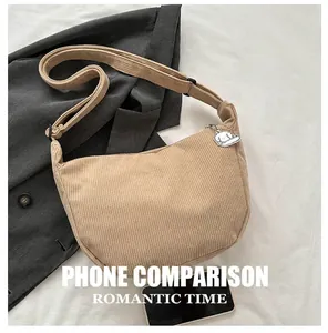 Detailed close-up of beige corduroy hobo bag with adjustable strap and phone for scale