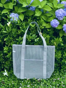 Macro detail of breathable grey mesh tote bag with reinforced handles for beach or spa