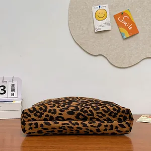 Dettaglio della borsa in tela con stampa leopardata su una scrivania in legno