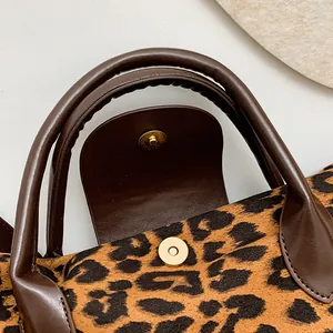 Dettaglio borsa leopardata con manico in PU marrone e chiusura magnetica oro