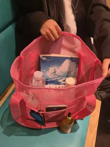 Pink mesh beach bag detail showing side pockets for phone and sunglasses storage
