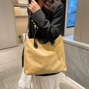Dettaglio della borsa tote in pelle scamosciata color zenzero con manici neri in pelle