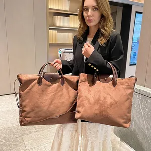 Dettaglio di una grande borsa tote in pelle scamosciata marrone con manici in pelle