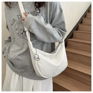 Detailed texture of white corduroy hobo bag with a cute cartoon puppy charm on shoulder