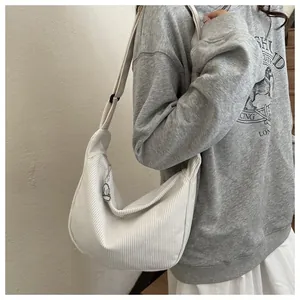 Detailed close-up of white corduroy hobo bag texture with a cute zipper pendant decoration