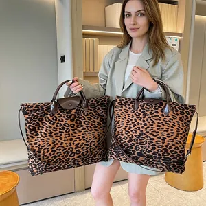 Dettaglio della borsa tote leopardata con manici in pelle marrone e tracolla regolabile