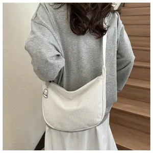 Detail of white corduroy crossbody bag texture with cute puppy pendant and zipper