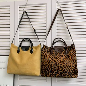 Grande borsa tote satinata e borsa a spalla leopardata su persiane bianche