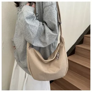 Detail of beige corduroy hobo bag with zip closure and plush cloud charm