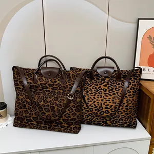 Dettaglio di borse tote leopardate con manici in pelle e chiusura a scatto metallica