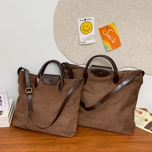 Dettaglio di borse tote in pelle opaca marrone scuro in due dimensioni per uso quotidiano