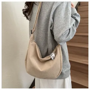 Detail of corduroy crossbody bag with adjustable strap and cute plush sheep charm