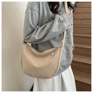 Detail of beige corduroy hobo bag texture with zipper and cute dog charm decoration