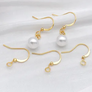 Ganci per orecchini placcati oro fai-da-te con perle su sfondo di seta bianca