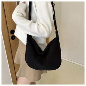Close-up of black corduroy hobo bag showing fine texture and crossbody shoulder strap