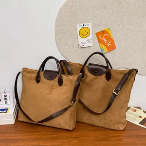Dettaglio della borsa tote opaca color cammello con manici in pelle e tracolla regolabile